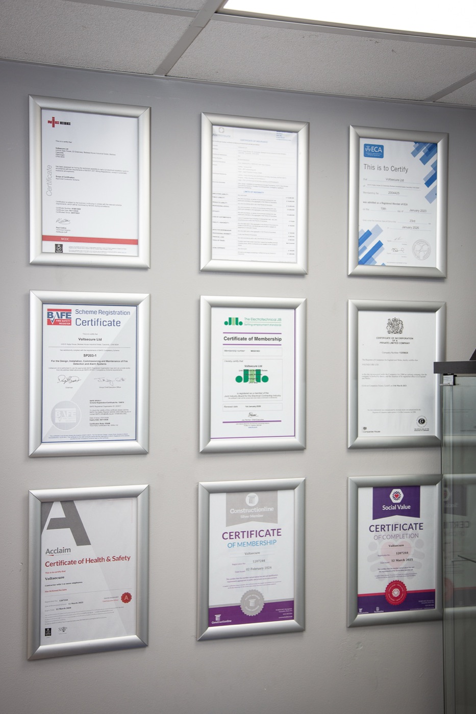 VoltSecure's certificate wall at the Caerphilly HQ - nine framed accreditations including BAFE, NICEIC, ECA, JIB, Constructionline and Acclaim