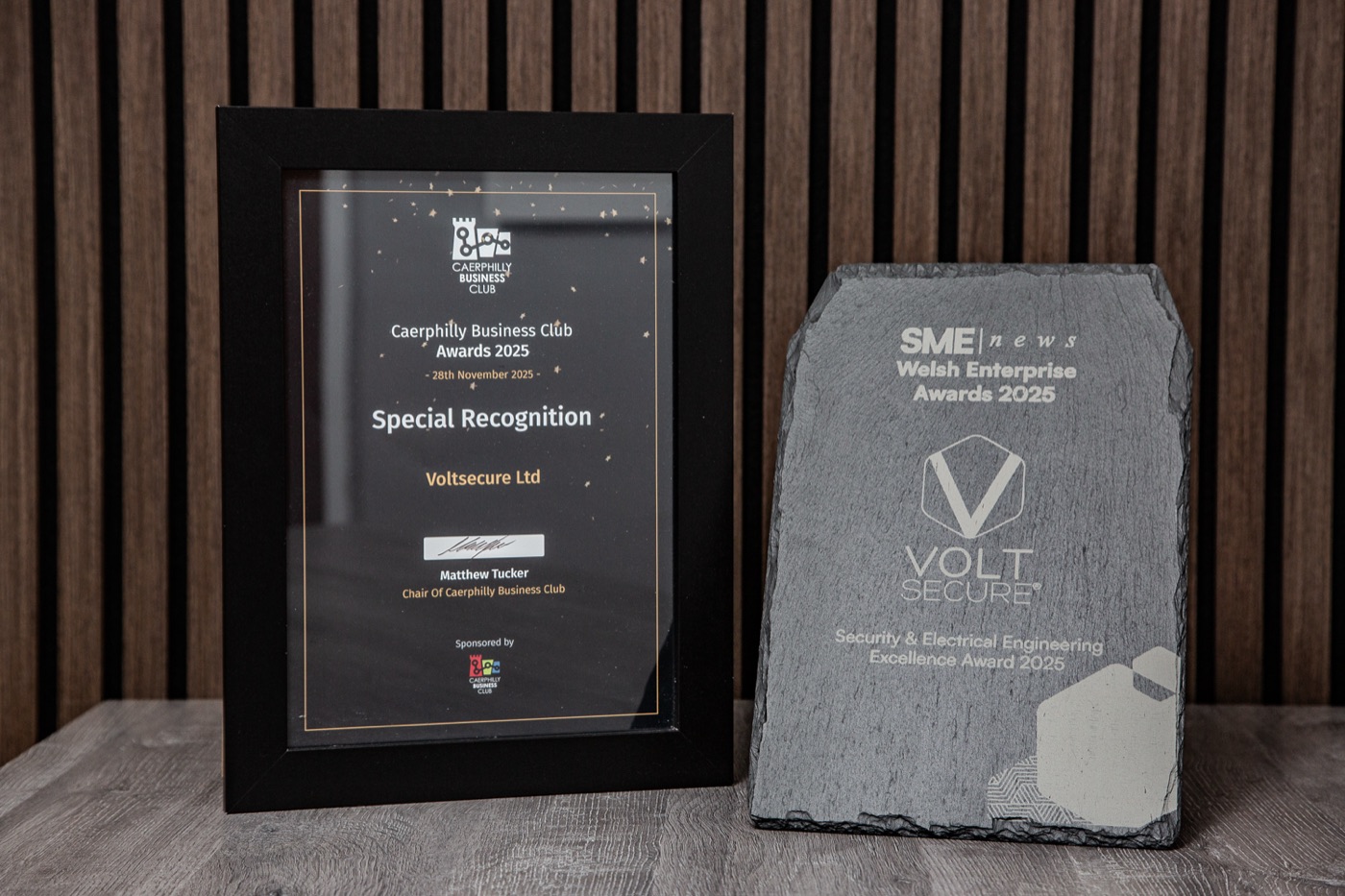 VoltSecure's 2025 award trophies displayed together - Caerphilly Business Club Special Recognition frame and SME News Welsh Enterprise Awards slate